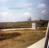 1979 picture of NASA rocket launch pad seen in distance with water tower - seen from tour bus thru window at Cape Canaveral, Florida, USA