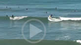 Image to play a video of a bunch of surfers on a nice sunny day